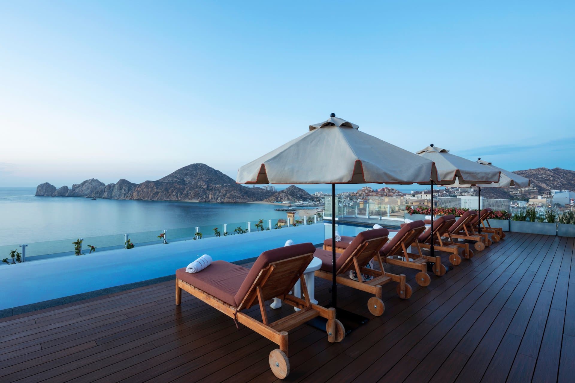 Lounge chairs on roof top by the pool near the ocean at a Noble House Hotels & Resorts property