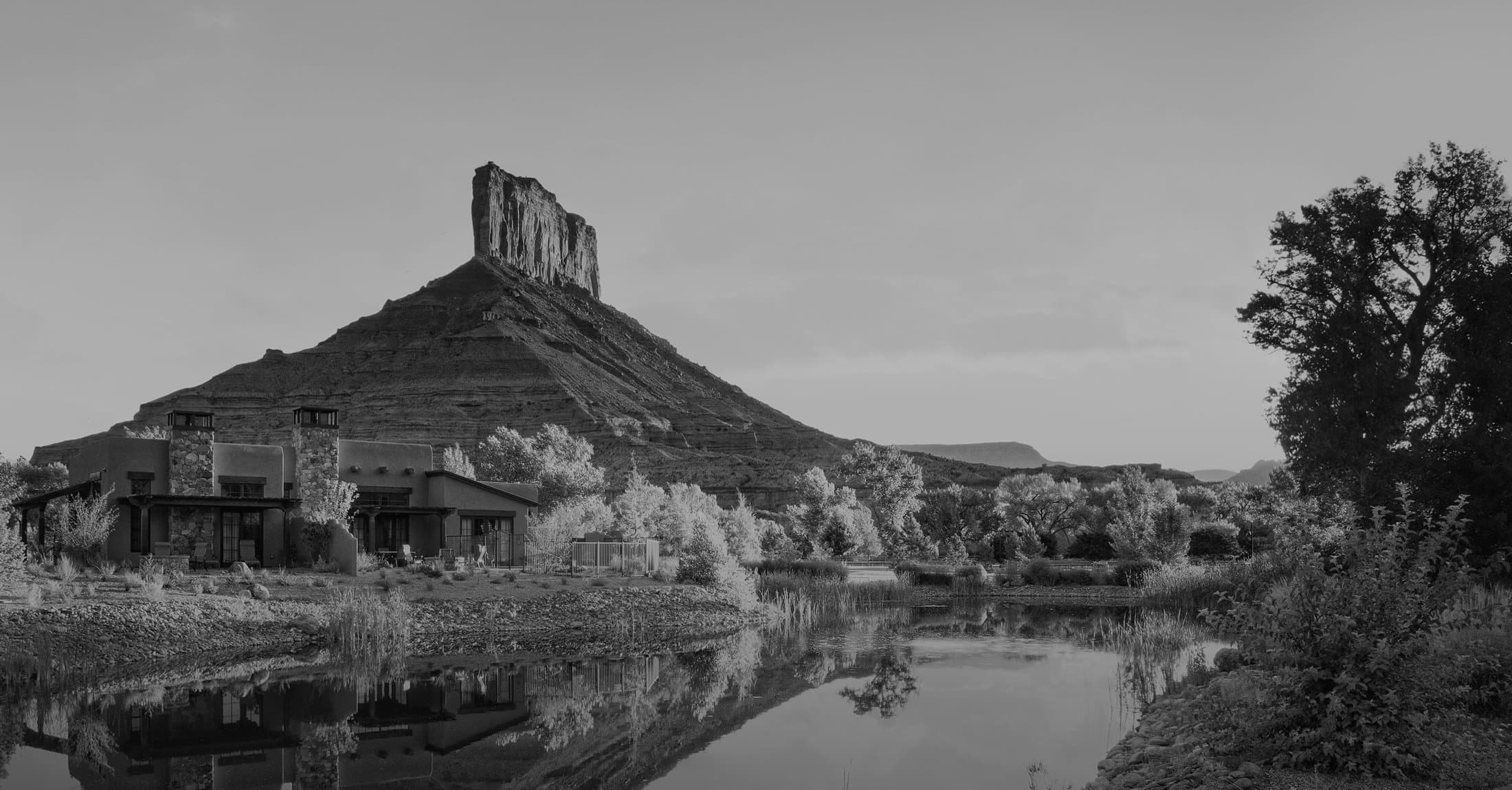 Gateway Canyons Resort & Spa building with water out front and mountain in the back in Gateway, Colorado