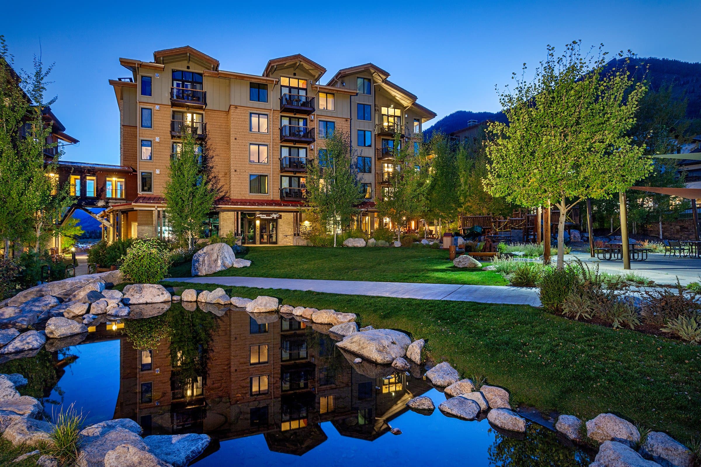 Exterior facade of Hotel Terra with a pond and trail in Jackson Hole, Wyoming