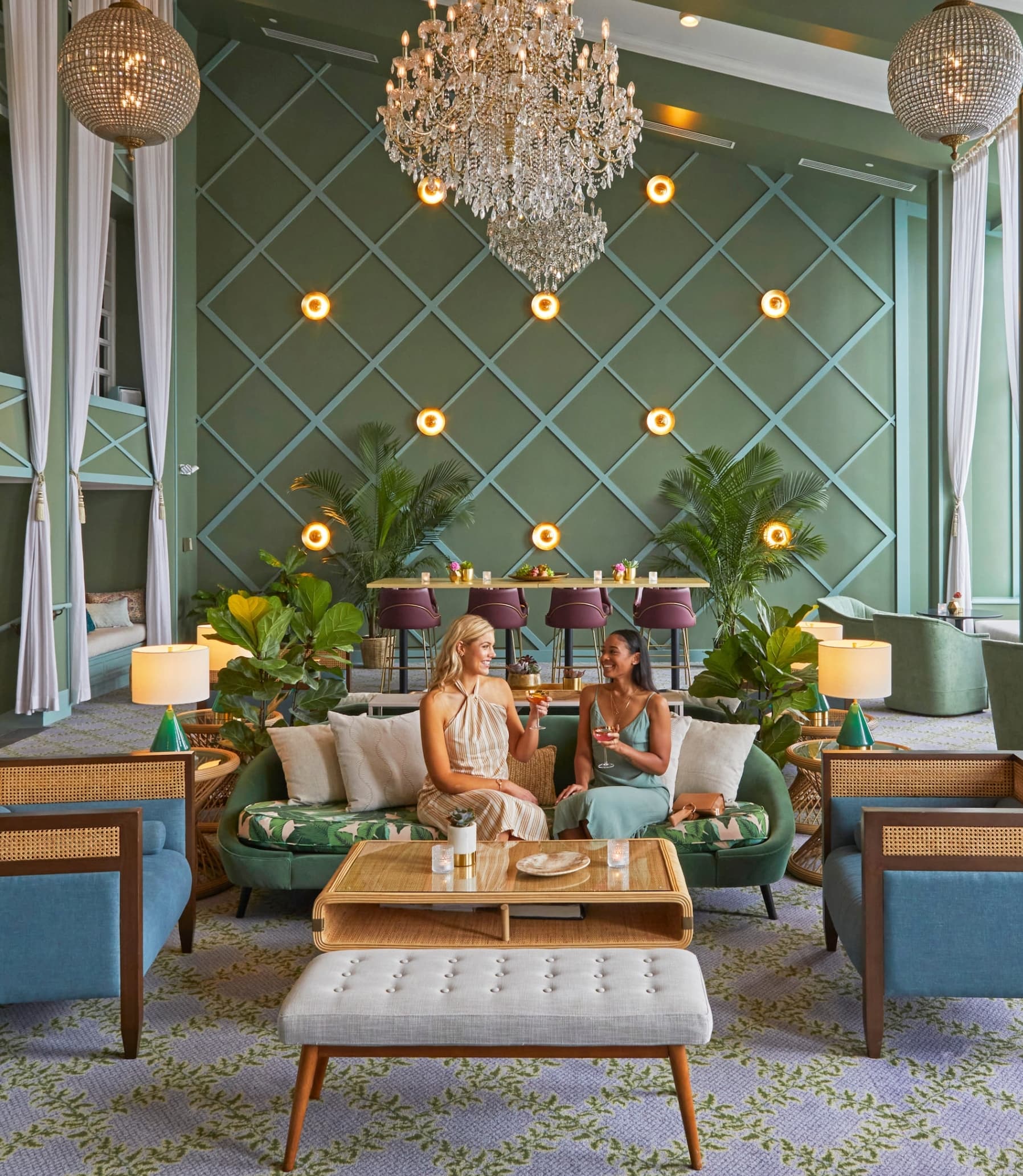 Two women enjoying their drinks in the seating area at a Noble House Hotels & Resorts property