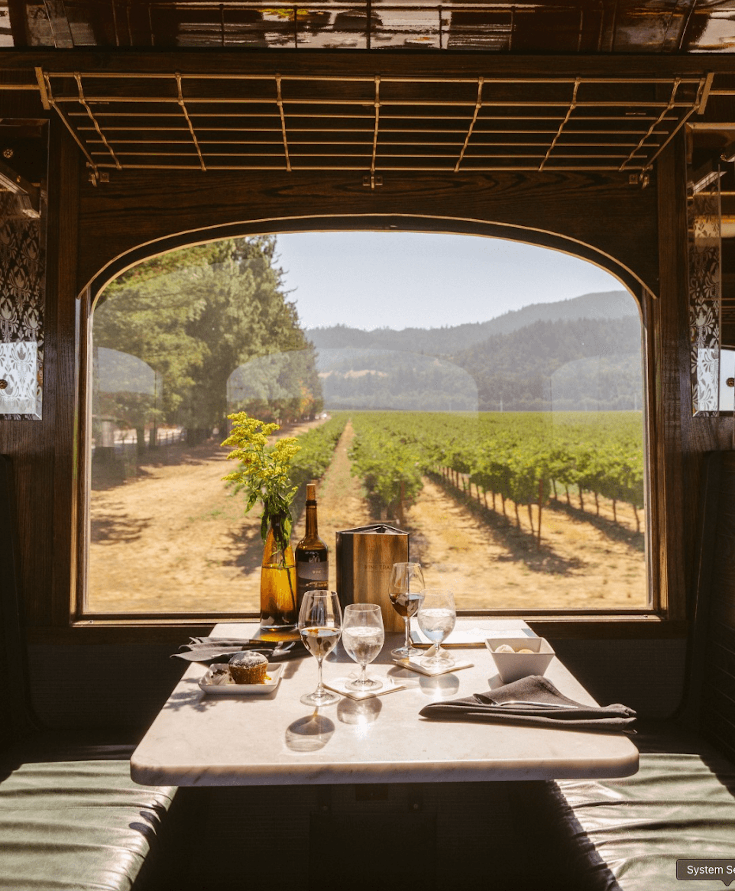 A table set next to a window overlooking a Noble House Hotels & Resorts property vineyard