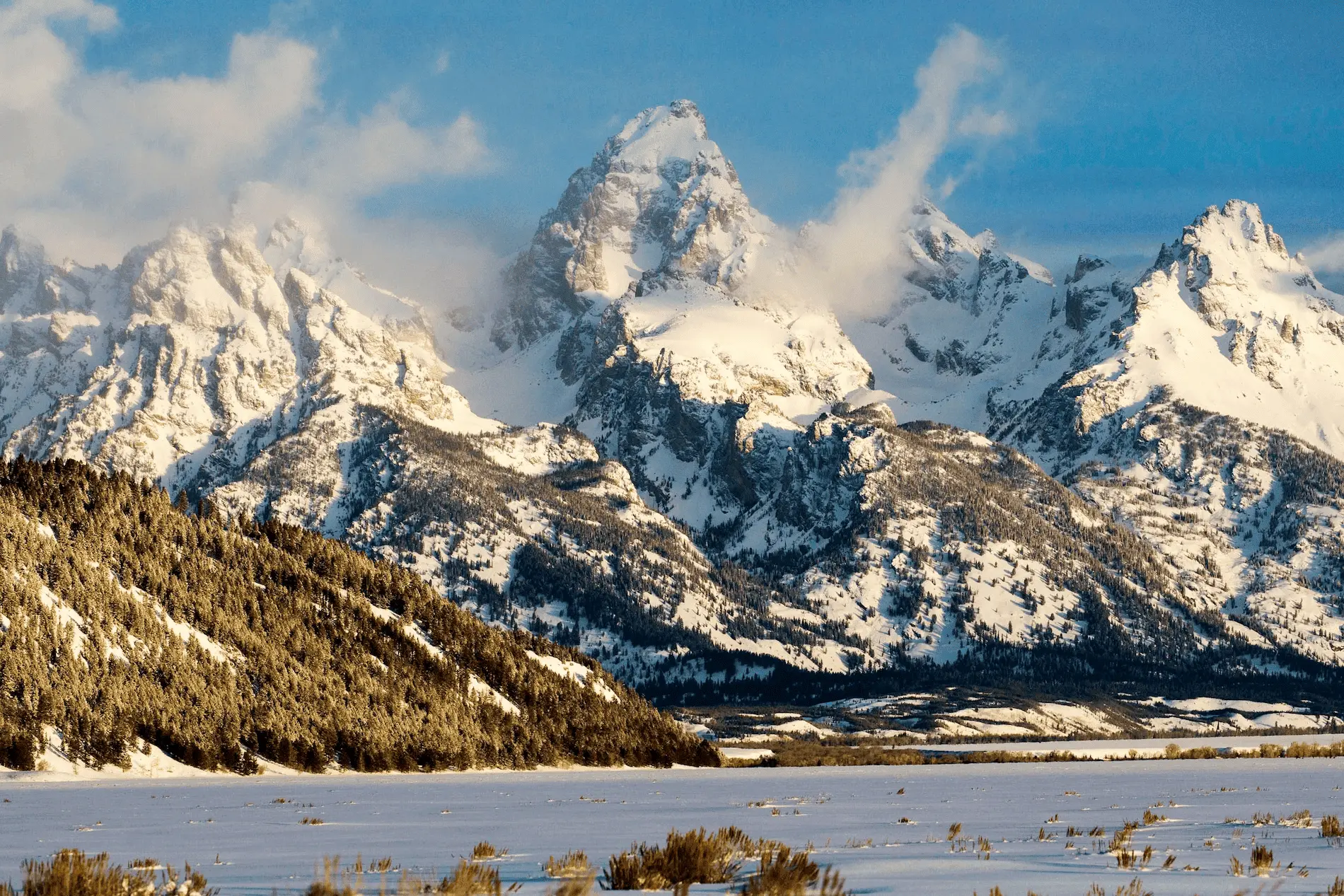 Snowy mountains with a frozen lake in front of it