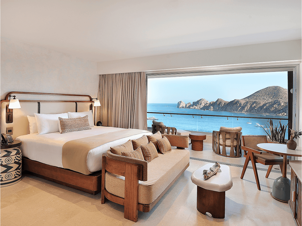 Noble House Hotels & Resorts property bedroom with big ocean view window, balcony and seating area