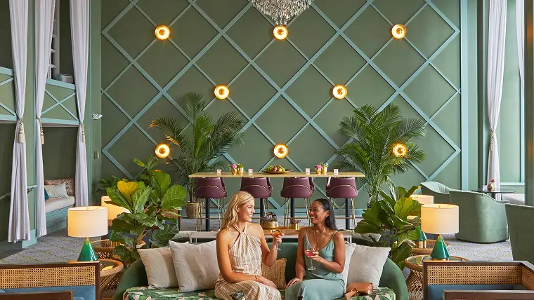 Two women enjoying their drinks in the seating area at a Noble House Hotels & Resorts property