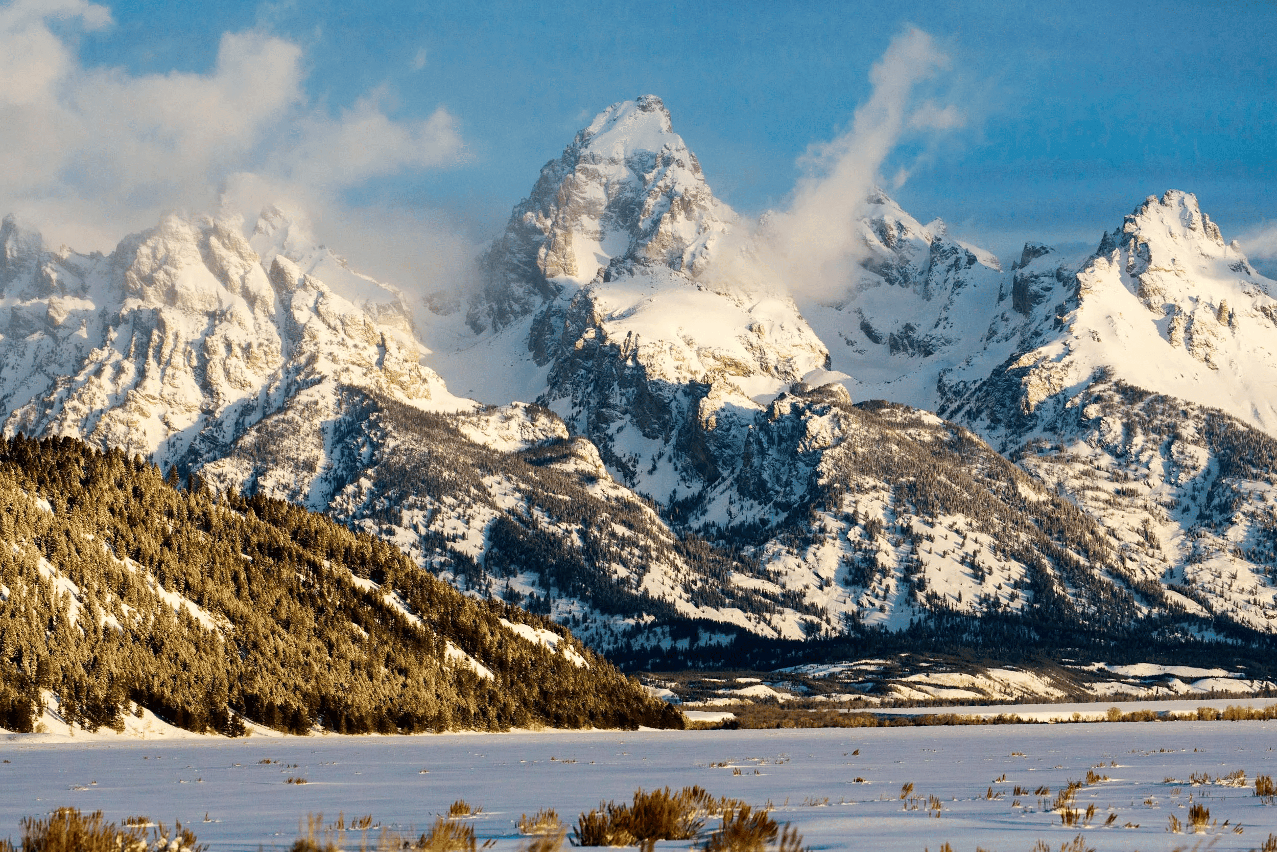 Snowy mountains with a frozen lake in front of it