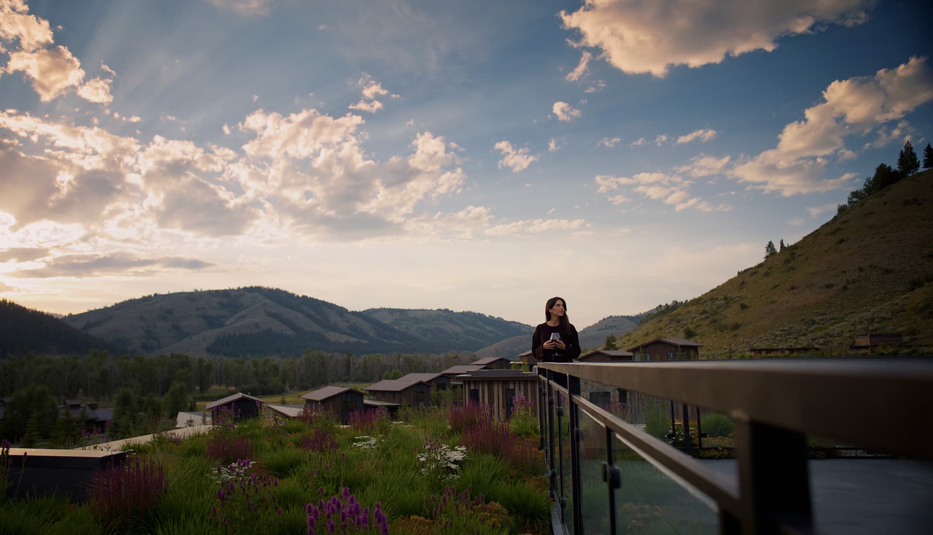 woman with wine glass looking at jackson hole fields